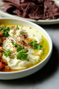 Chickpeas and tomato sofrito with hummus and purple taco chips