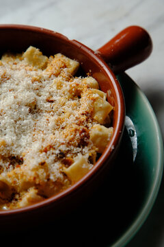 Guanciale and four cheese truffled mac in a red mug on a green plate