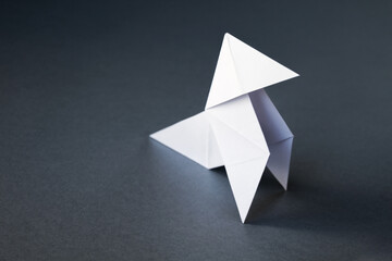 White paper hen origami isolated on a grey background
