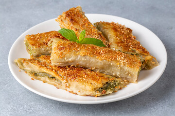 Greek cuisine dishes; spanakopita Sesame on handmade spinach feta cheese pie in the oven. Turkish name; ispanakli borek