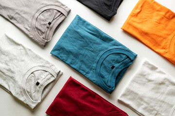 A collection of colorful plain t-shirts photographed on the table.