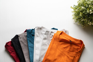 A collection of colorful plain t-shirts photographed from above.