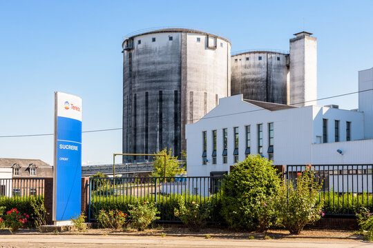 Origny-Sainte-Benoite, France - August 7, 2022: Buildings and concrete silos of the sugar refinery of Tereos, a french cooperative sugar group, on a sunny summer day.
