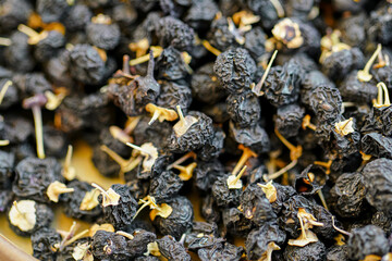 There are many naturally dried black wolfberries on the table