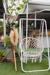 A white swing made of iron in a public place.