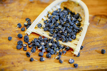 There are many naturally dried black wolfberries on the table