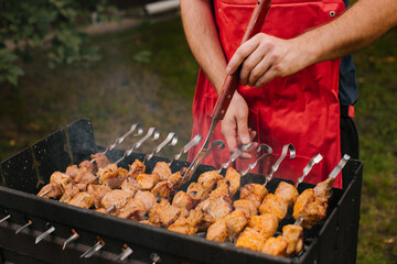 Autumn hot fire BBQ on the grill on a green meadow. Pork skewers.	
