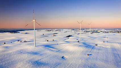Alternative energy in winter. Winter wind turbine on snowy field.