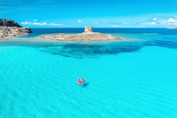 Foto op Plexiglas La Pelosa Strand, Sardinië, Italië Bovenaanzicht van prachtig zeegezicht. Luchtfoto van de groep mensen drijft op een catamaran in helder blauw water. Populair strand La Pelosa, Sardinië, Italië
