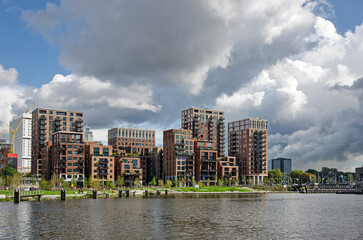 Rotterdam, The Netherlands, September 28, 2022: recently completed Little C neighbourhood and adjacent park under a sky with dramatic clouds