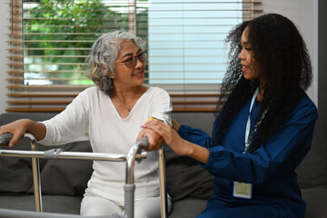 Health visitor talking, giving advice to elderly woman during home visit. Nursing home concept