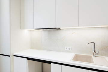 Fototapeta na wymiar white new clean kitchen in the house. furniture with lighting