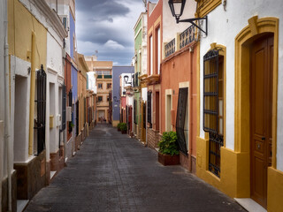 Obraz premium Typical street of colorfully painted houses and barred windows