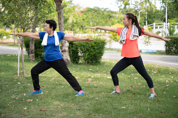 Asia senior and teenager woman training yoga at garden	