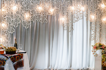 Wedding decorations in luxury ceremony. Arch with hanging garland of light bulbs at evening ceremony, copy space.