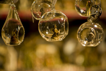Advent Bazaar Stalls with glass, wooden, ceramic christmas souvenirs in shops. Close up of festive decorations for tree in winter street night market during new year's holiday. Illuminated fair kiosk