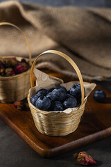 Blueberries in a basket on a wooden board