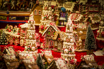 Advent Bazaar Stalls with glass, wooden, ceramic christmas souvenirs in a shop. Close up of festive decorations for tree in winter street night market during new year's holiday. Illuminated fair kiosk