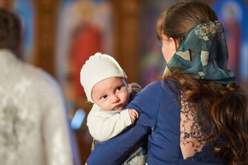 A small child at a baby christening ceremony in a church. .Baptism of the newborn. The sacrament of baptism. Child and God