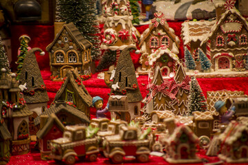 Advent Bazaar Stalls with glass, wooden, ceramic christmas souvenirs in a shop. Close up of festive decorations for tree in winter street night market during new year's holiday. Illuminated fair kiosk
