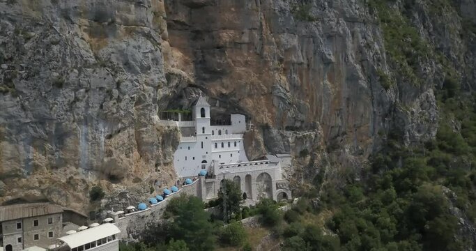 Wonderful church in the rock called Ostrog and its located in Montenegro. Landscape nature with human touch. Aerial 4k video footage for travel content. Adventure trip in Crna gora. National parks.