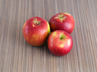 Fototapeta na wymiar Three red organic apples on bamboo napkin