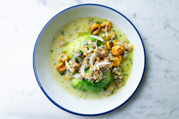 Cockles ceviche with avocado, red onion and puffed corn. Traditional recipe from Peru.
