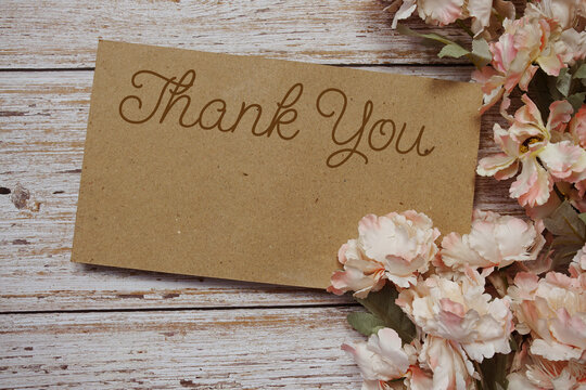 Thank You typography text with flowers frame on wooden background