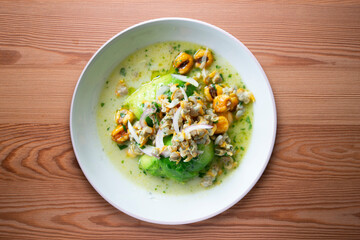 Cockles ceviche with avocado, red onion and puffed corn. Traditional recipe from Peru.