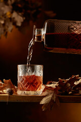 Whiskey is poured into a glass with ice.