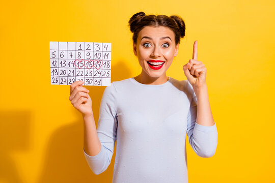 Photo of adorable excited girl dressed white shirt pointing finger holding planner isolated yellow color background