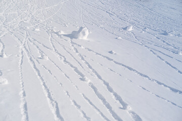 gentle slope of mountain, white snow lies on flat surface, lumps of snow roll down, snow-covered...