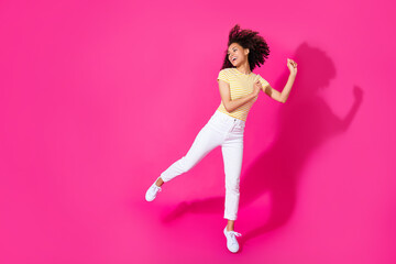 Ful body photo of nice young girl dancing enjoy party poster dressed stylish yellow striped clothes isolated on shine pink color background