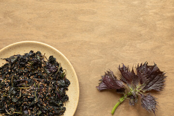 Asian style Shiso (Perilla) leaves stir fry with sesame seeds. Top view.