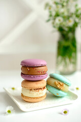 Delicious fresh macaroons with filling on a light wooden background