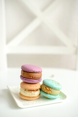 Delicious fresh macaroons with filling on a light wooden background