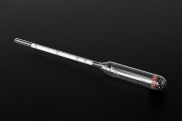 hydrometer, a tool for measuring the density of the battery electrolyte, on a black background