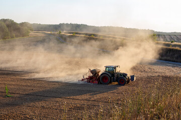tractor plowing a brown dusty field