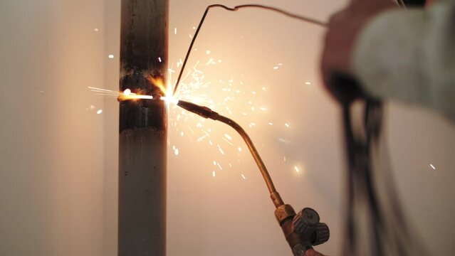 man welds pipes by gas welding
