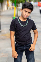 Cute Boy style poses with black t.shirt and jean pant with big silver chain - boy neckless