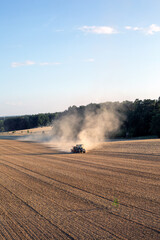tractor plowing a brown dusty field