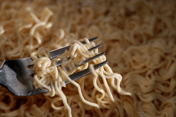 Instant noodles on metal fork 