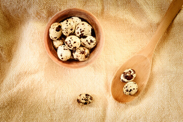 Still life with a bowl and a wooden ladle with quail eggs.