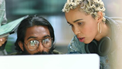 Teamwork, collaboration and diversity with a design team working on a computer in their creative office. A group of young business people at work and in discussion for marketing and advertising