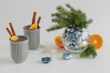 Christmas mulled wine. Punch, grog. Next to it are oranges, Christmas decorations and fir branches in a glass vase on a light background.
