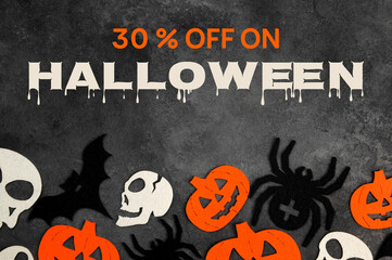 Halloween sale banner with bats,spiders,pumpkins and skulls on dark concrete background.