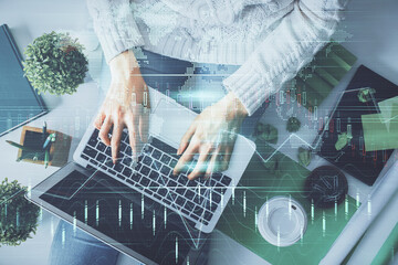 Double exposure of woman hands working on computer and forex chart hologram drawing. Top View....