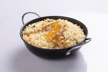 Chicken biryani , bangladeshi style chicken dhum biriyani made using chinigura rice and spices arranged in a black bowl with white background, isolated
