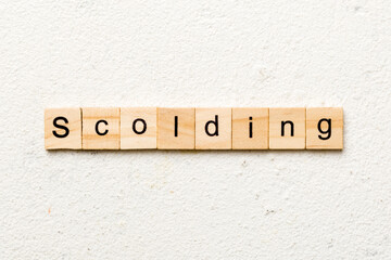 scolding word written on wood block. scolding text on table, concept