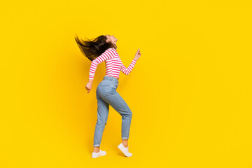 Fototapeta na wymiar Full length profile side photo of positive girlfriend trendy striped outfit have rest relax empty space isolated on yellow color background
